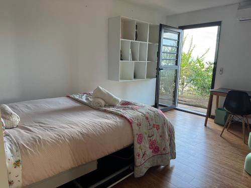 a bedroom with a bed with a blanket on it at Villa Californienne proche Nouméa in Païta