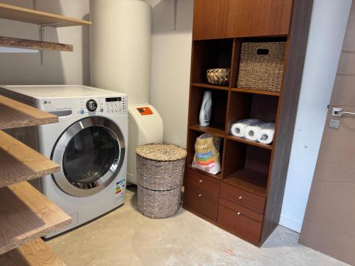 a laundry room with a washing machine in it at Villa Californienne proche Nouméa in Païta