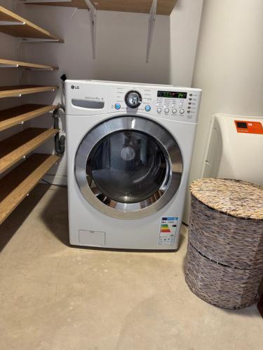 a washing machine is sitting next to a basket at Villa Californienne proche Nouméa in Païta