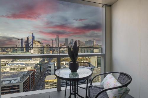 a balcony with a table and chairs and a view of a city at Docklands Harbour & City Views Pool, Free Onsite Parking , Yoga & Gym in Melbourne