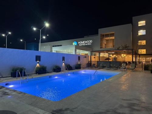 a swimming pool in front of a building at night at Homewood Suites By Hilton Saltillo in Saltillo
