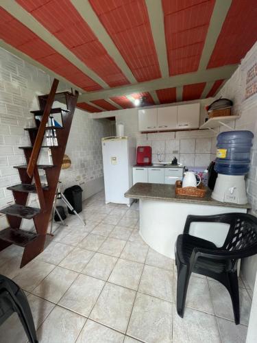 a kitchen with a white refrigerator and a table and chairs at Casa chalé em Tamandaré in Tamandaré