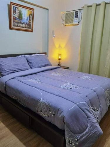 a bedroom with a bed with a blue blanket at Asteria Residences Paranaque Sucat 2 Bedroom in Sampong