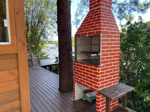 a brick oven sitting on top of a deck at Chalé na praia e a beira do Rio Mampituba in Passo De Torres