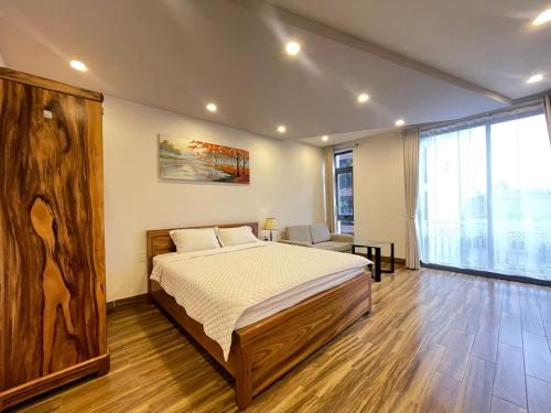 a bedroom with a bed and a large window at Roma Hotel Da Nang Free Pool & BBQ Garden in Da Nang