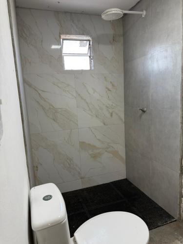 ein Bad mit einem weißen WC und einem Fenster in der Unterkunft SRBG Casa em Barra Grande-PI in Barra Grande