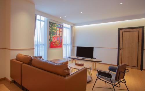 a living room with a couch and a television at Lub d Bangkok Chinatown - Steps from Sam Yod MRT Station in Bangkok