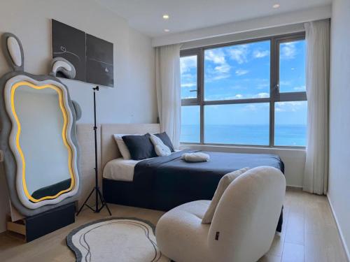 a bedroom with a bed and a chair at Sea Breeze Apartment - The Song Căn Hộ Du Lịch Biển Vũng Tàu in Vung Tau