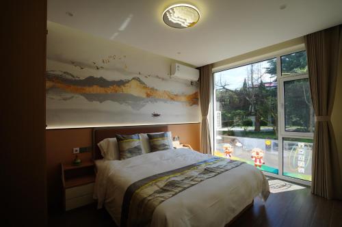a bedroom with a large bed and a large window at Beidaihe Yijing Hotel in Shanzhuang