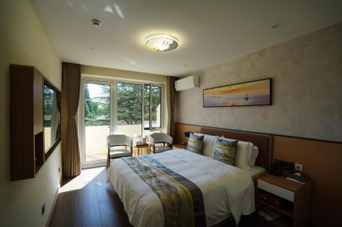 a hotel room with a bed and a window at Beidaihe Yijing Hotel in Shanzhuang