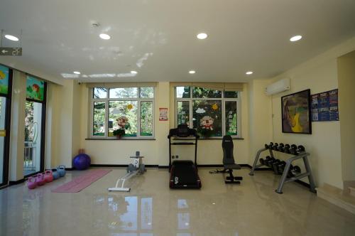 a room with a gym with exercise equipment and windows at Beidaihe Yijing Hotel in Shanzhuang