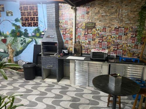 a kitchen with a counter with a stove and a table at Casa Dos Carandas in Itanhaém