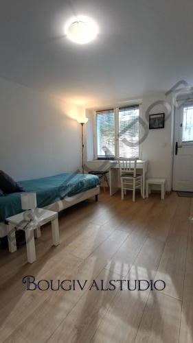 a bedroom with a bed and a table and window at Studio meublé à Bougival in Bougival