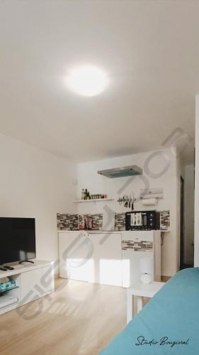 a white room with a bed and a television at Studio meublé à Bougival in Bougival