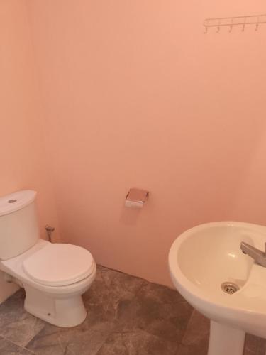 a bathroom with a toilet and a sink at Talalla Bay Inn Beach Bungalow in Talalla