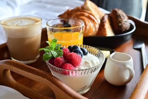 a table topped with a bowl of yogurt and fruit at Coconut Lane Bangkok in Bangkok