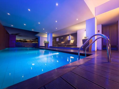 a swimming pool in a hotel with blue lighting at Lake Avenue Hotel Kandy in Kandy