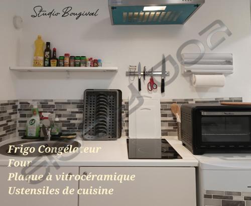 a kitchen with a microwave and a stove top oven at Studio meublé à Bougival in Bougival