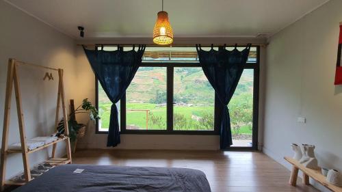 a bedroom with a large window and a bed at The Culture Home in Sa Pa