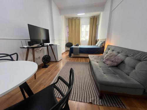 een woonkamer met een bank en een tafel bij Loft no Centro- Lapa, Consulado, Praia,Metrô e AR! 605 in Rio de Janeiro