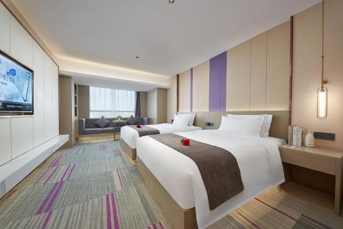 a hotel room with two beds and a television at Lavande Hotel Guangzhou Panyu Hanxi Changlong Dashi Subway Station in Guangzhou