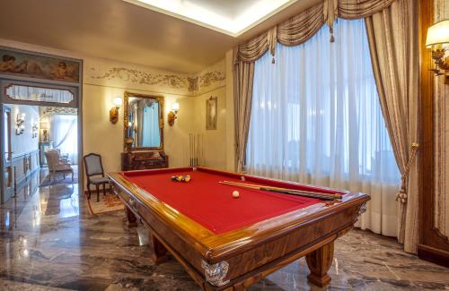 a pool table in a living room with a pool at Abano Ritz Hotel Terme in Abano Terme