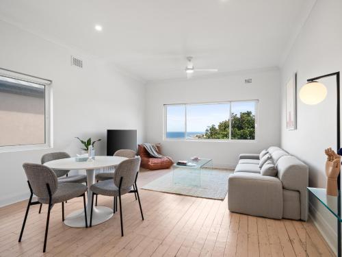a living room with a couch and a table and chairs at The Fletcher Bondi in Sydney