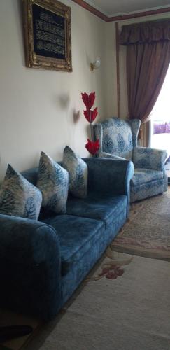 a living room with a blue couch with pillows at شقة للايجار in Sharm El Sheikh
