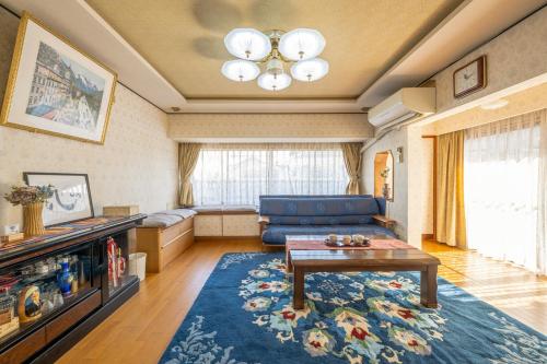 a living room with a blue couch and a table at 岐阜羽島の隠れ家 古民家cocone in Hashima