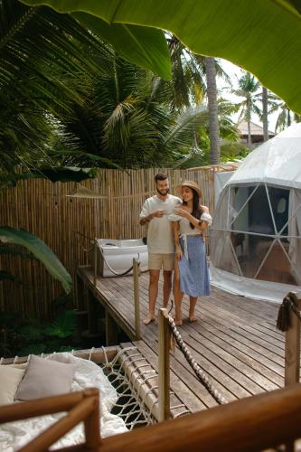 a man and a woman standing on a wooden deck at La Royale Nusa Penida in Nusa Penida