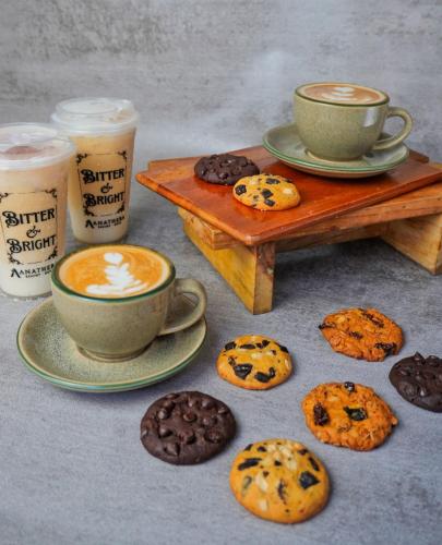a table with two cups of coffee and cookies at Anathera Resort Kuta in Kuta