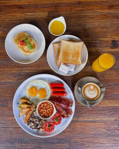 a table with plates of breakfast food and a cup of coffee at Anathera Resort Kuta in Kuta