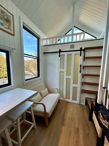 a room with a couch and a table and windows at Wollongong Tiny Home