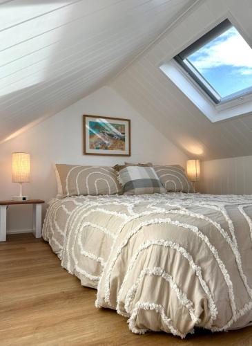 a bedroom with a bed with a skylight at Wollongong Tiny Home