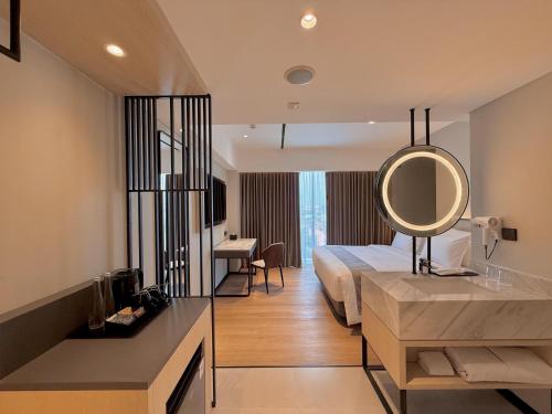a hotel room with a bed and a mirror at FortunaSuites Malioboro Yogyakarta in Sentool