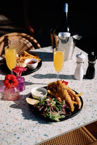 a table with a plate of food and glasses of orange juice at The Continental Hotel in Broome