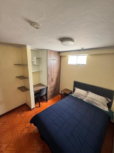 AbancayにあるModerno Depa Céntrico en Abancayのベッドルーム(青いベッド1台、デスク付)