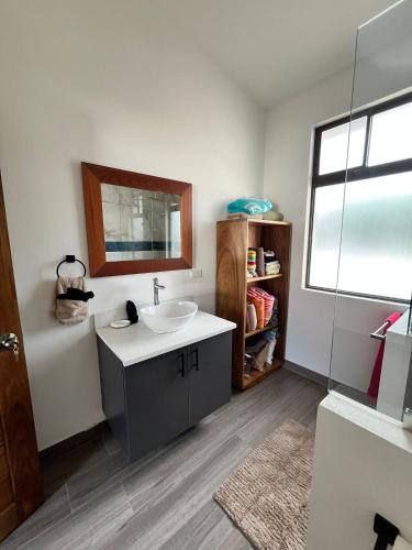 a bathroom with a sink and a mirror at Casa Aurora with Private Patio & Pool in Coco