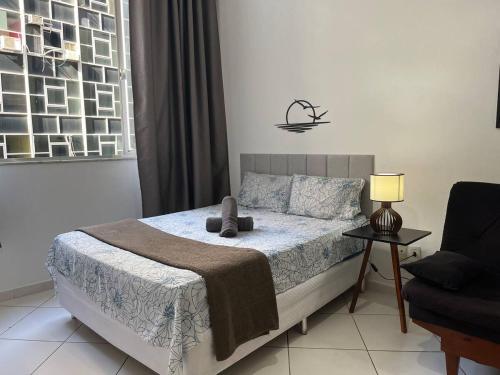 a bedroom with a bed and a lamp and a chair at Stúdio no Centro- Lapa, Consulado, Praia e Metrô! 1101 in Rio de Janeiro