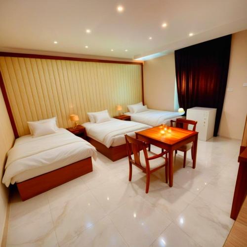 a hotel room with two beds and a table at Pyramids Grand View Hotel in Cairo