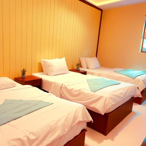 three beds in a room with yellow walls at Pyramids Grand View Hotel in Cairo