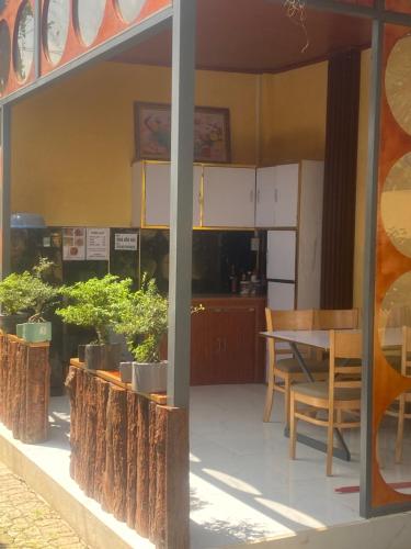 Tây NinhにあるNhà bên núiのテーブルと椅子と木のあるキッチン