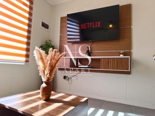 a living room with a tv on a wall at Casa Perfecta para Vacaciones Familiares -Vista al Volcán - Parking Free in Villarrica