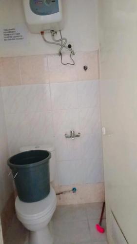 a bathroom with a bucket on top of a toilet at Villa Highland No 9 Berastagi View in Berastagi