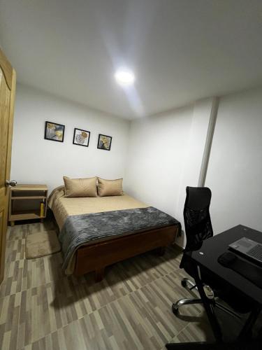 a small bedroom with a bed and a desk at Apartamento en Ríonegro con excelente ubicación in Rionegro