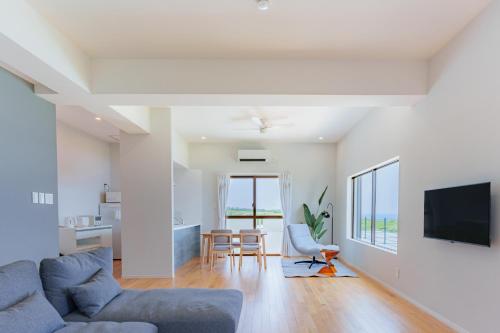 宫古岛Cliff Sky的带沙发和桌子的客厅