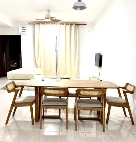 a dining room with a wooden table and chairs at Rizku Homestay Port Dickson 4 Bedroom 4 Bathroom in Pasir Panjang