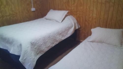two beds sitting next to each other in a room at Los Teros in Chile Chico