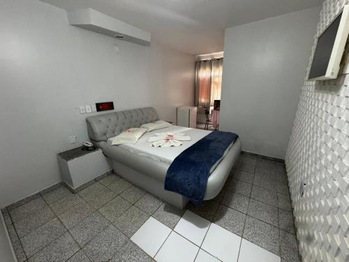 a bedroom with a bed with a blue blanket at Caribe Palace Hotel Taguatinga in Brasilia