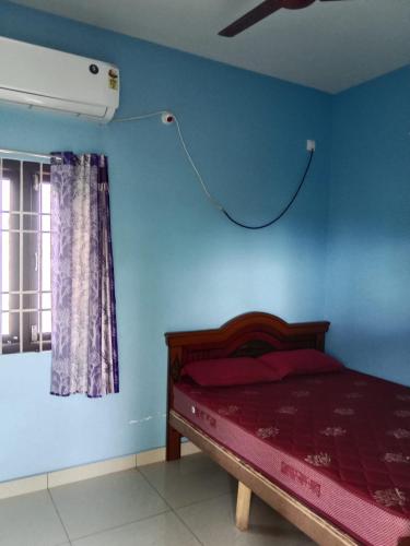 a bedroom with a bed and a ceiling fan at Uddish Residency in Virāmpattinam